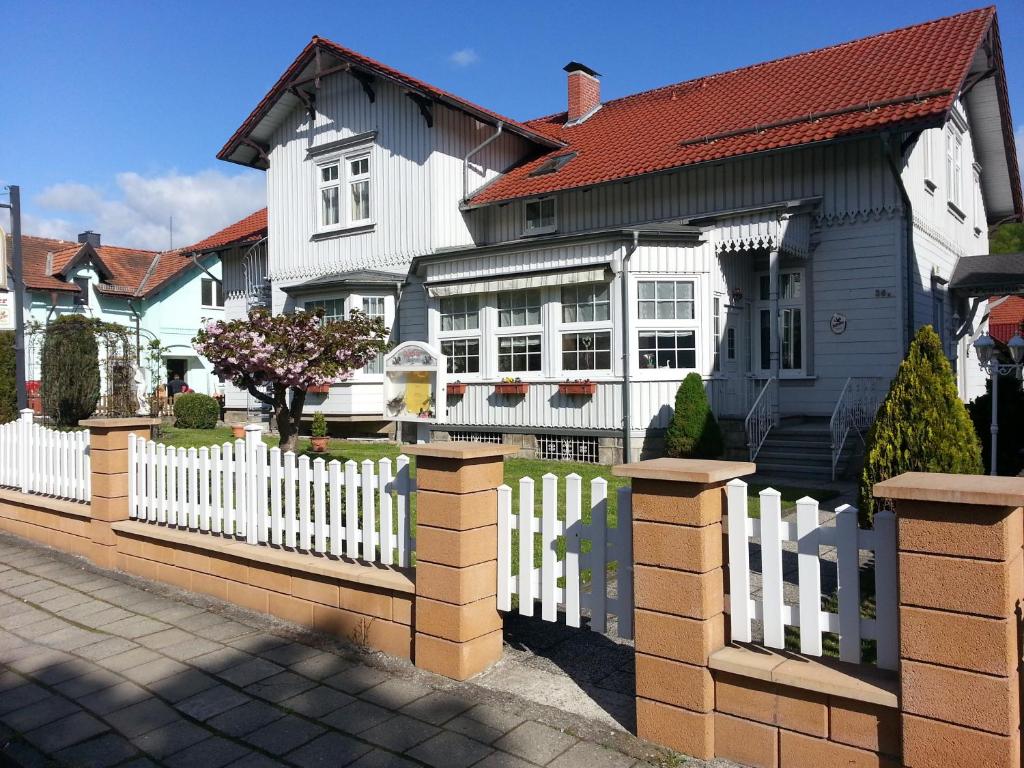 a white picket fence in front of a house at Hotel-Pension Deter in Wernigerode