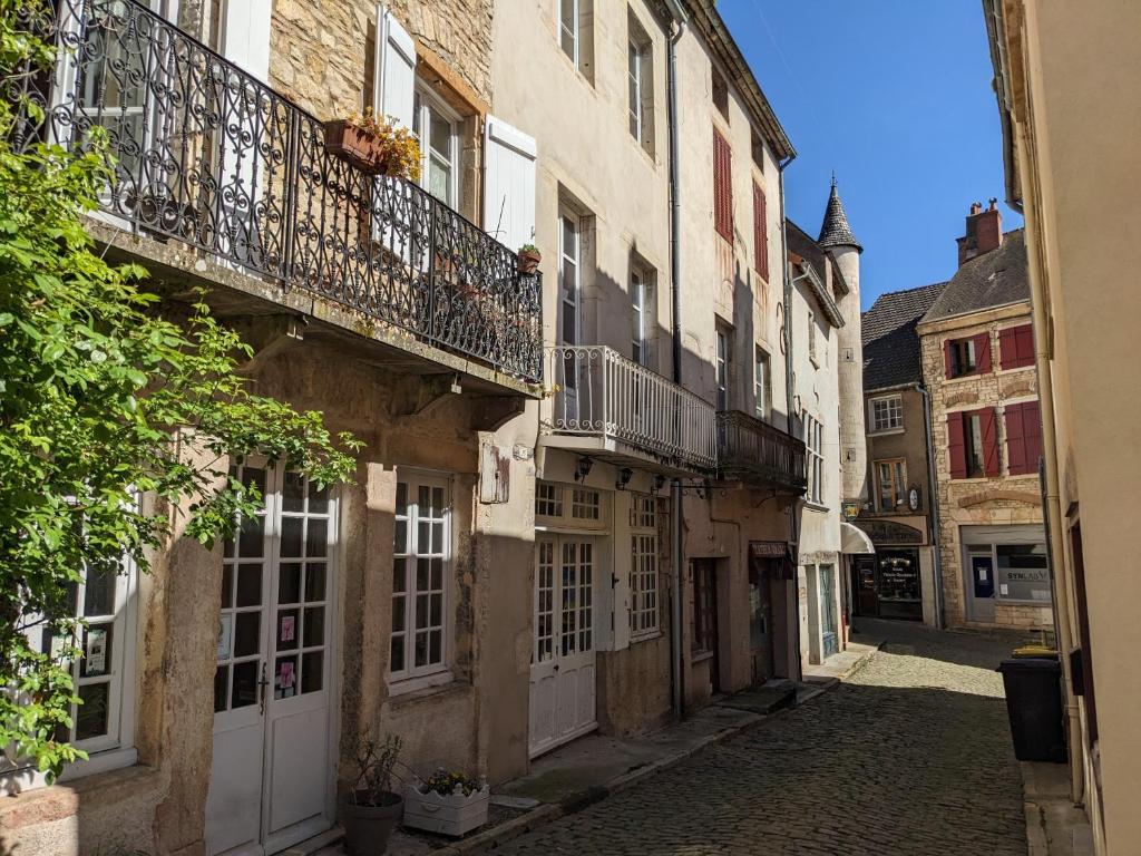 an alley in an old building with a balcony at La Licorne - Renovated Townhouse in St Gengoux in Saint-Gengoux-le-National