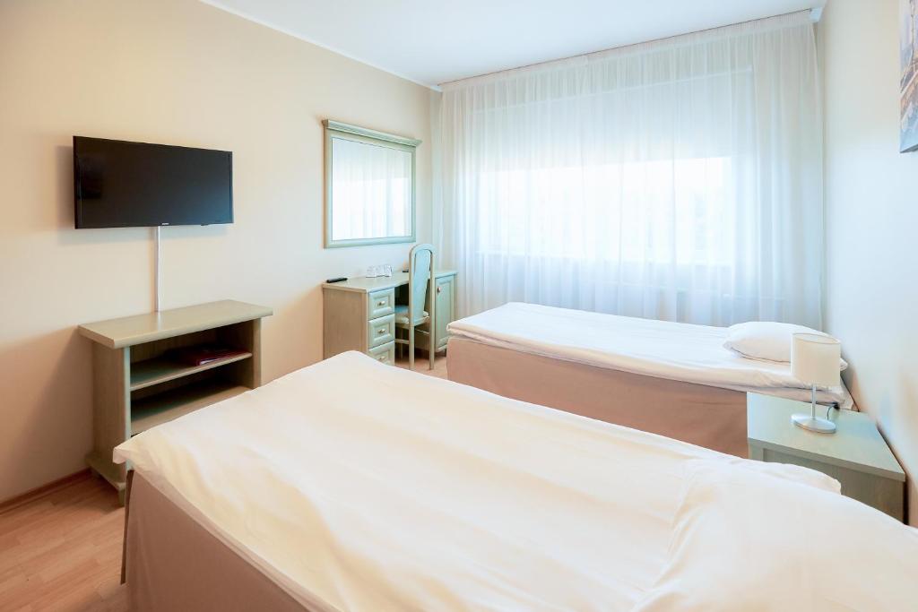 Postel nebo postele na pokoji v ubytování Hotel Dzingel