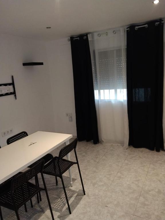 a room with black curtains and a table and chairs at piso pilar in Chiclana de la Frontera