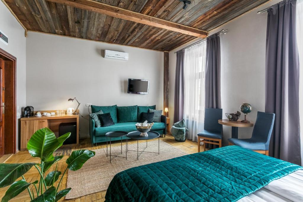 1 dormitorio con 1 cama verde y 1 sofá en Aparthotel Pergamin, en Cracovia