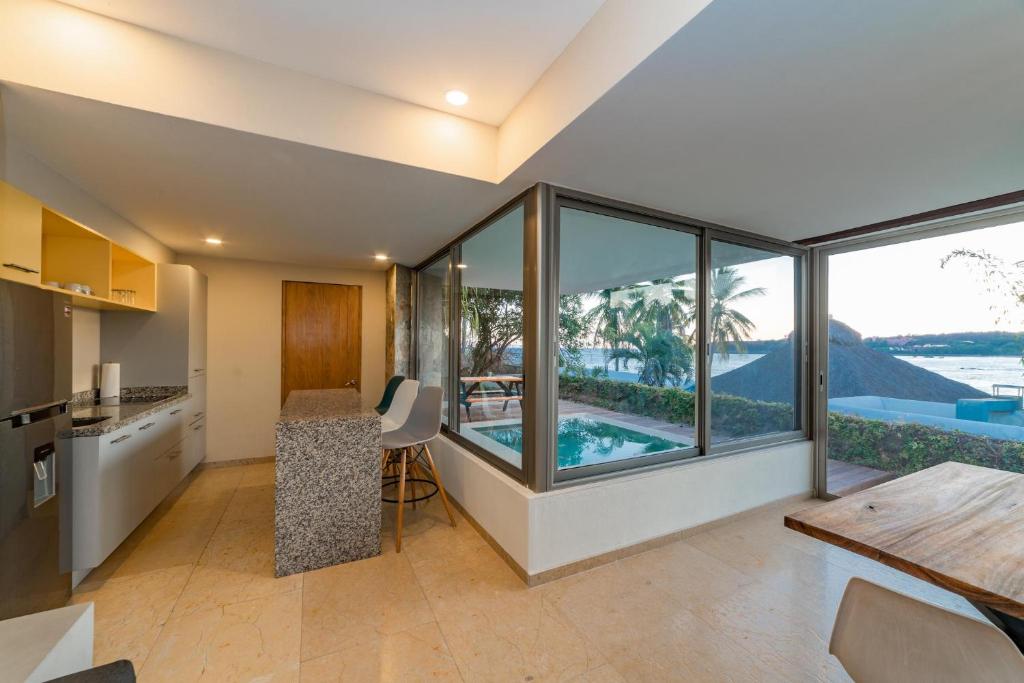 a kitchen and dining room with a view of the ocean at 2062 - Lu Iba Condo 1 in Santa Cruz Huatulco