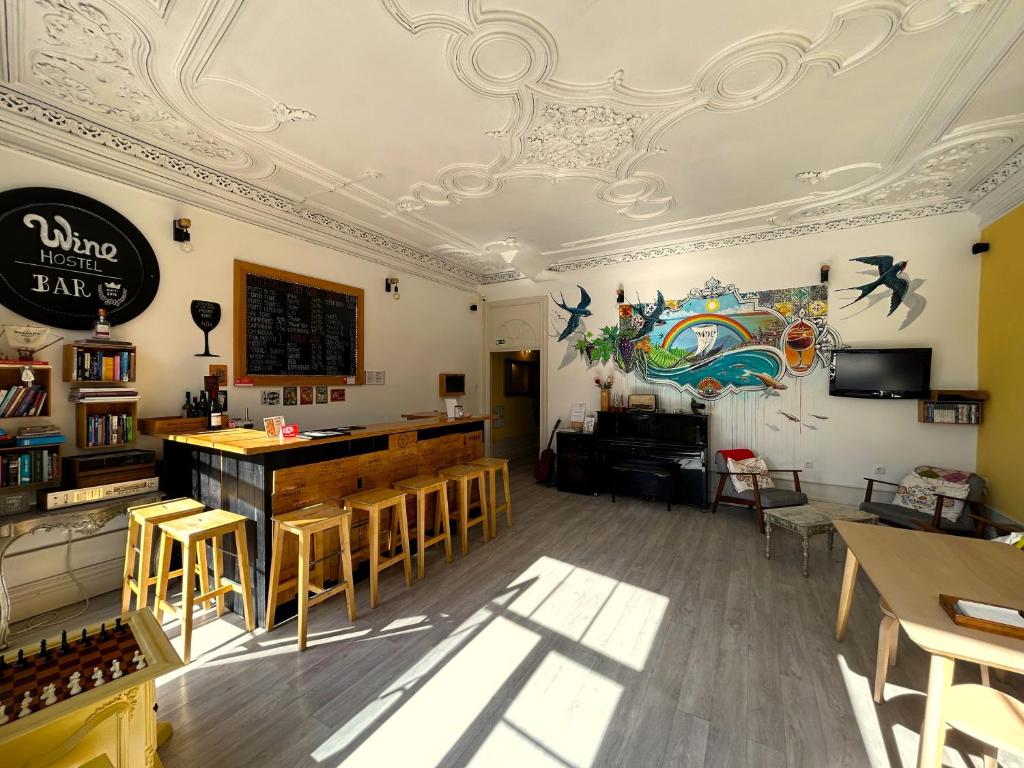 ein Zimmer mit einer Bar und einigen Tischen und Stühlen in der Unterkunft Porto Wine Hostel in Porto