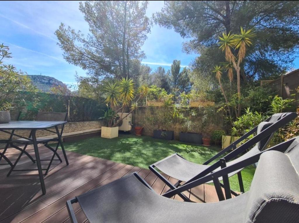 a patio with a table and chairs in a yard at Jardin Privé ds le Centre de Cassis - Parking - Plage à 500m in Cassis