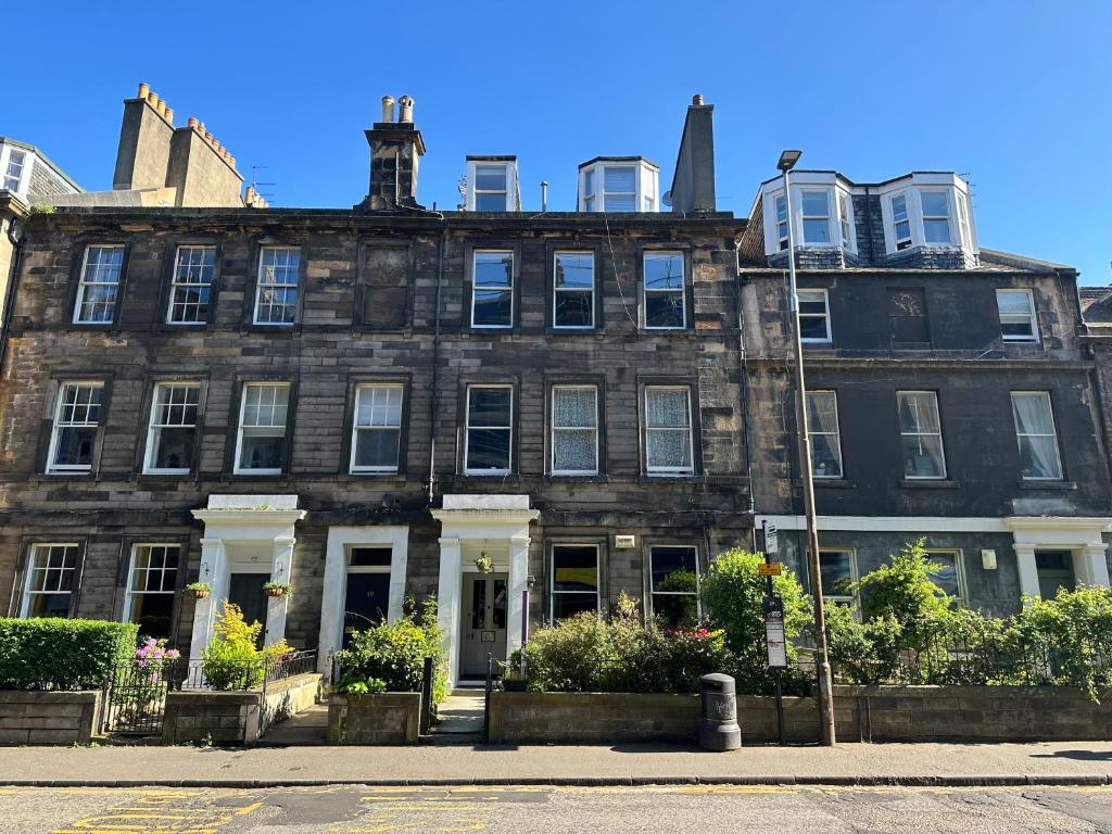 un gran edificio de ladrillo con puertas y ventanas blancas en The Valentine - Townhouse Hotel, en Edimburgo