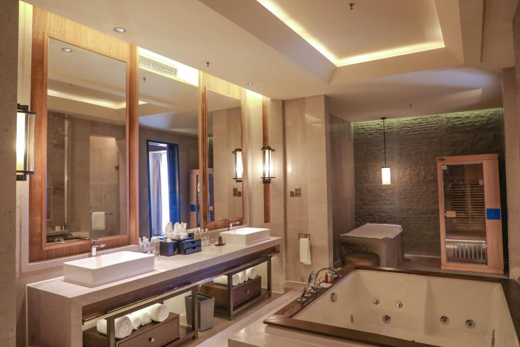 a bathroom with two sinks and a bath tub at Haikou Marriott Hotel in Haikou
