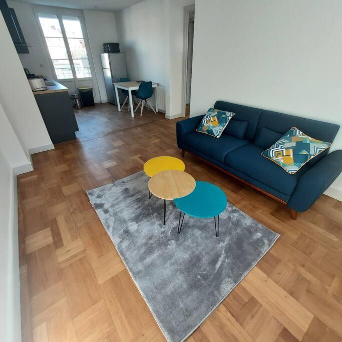 a living room with a blue couch and two tables at Appartemement F2 refait à neuf hyper centre in Coutances
