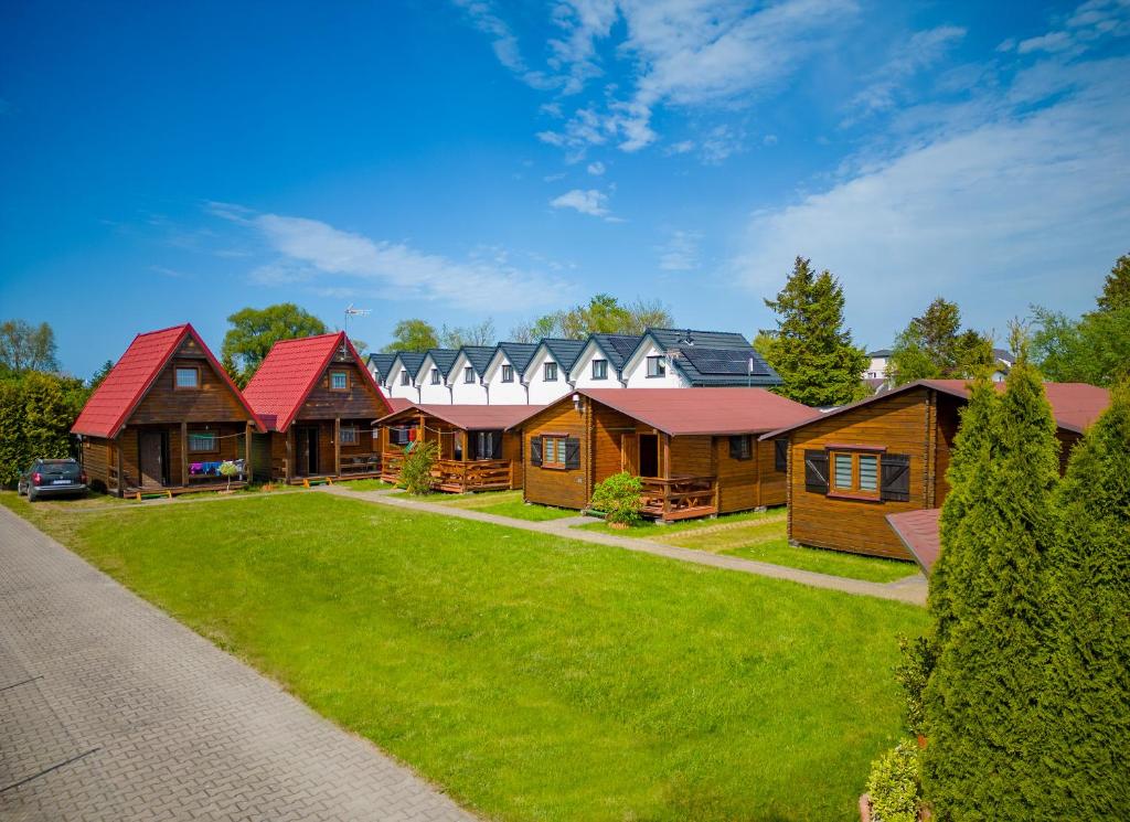 a row of log homes with red roofs at Uroczy Zakatek in Chłopy