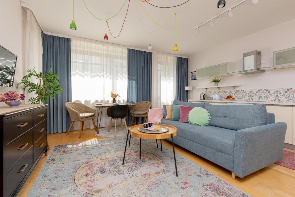 sala de estar con sofá azul y mesa en Wincentego Park Apartment by Renters en Varsovia