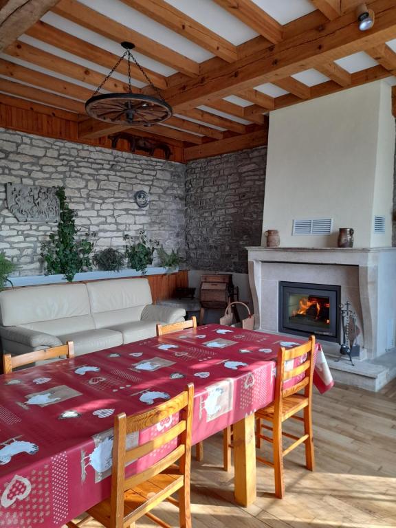 un salon avec une table et une cheminée dans l'établissement Gite Ancien Lavoir, à Viserny
