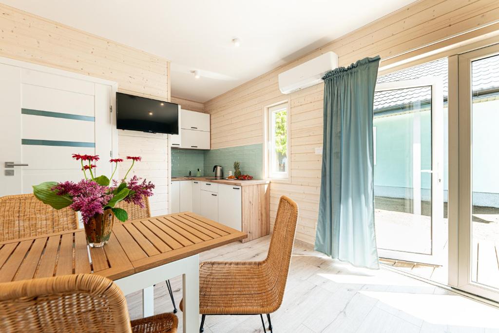 una cocina con una mesa de madera y un jarrón de flores en MIELENKO BEACH, en Mielenko