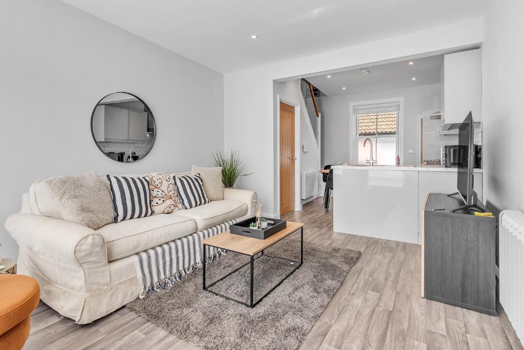 a living room with a couch and a kitchen at Surrey Street Duplex in Norwich