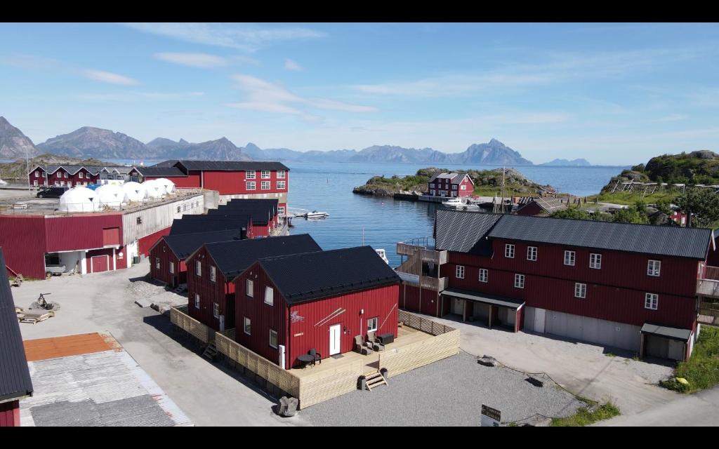 a town with red buildings and a body of water at Finnvika Lodges in Stamsund