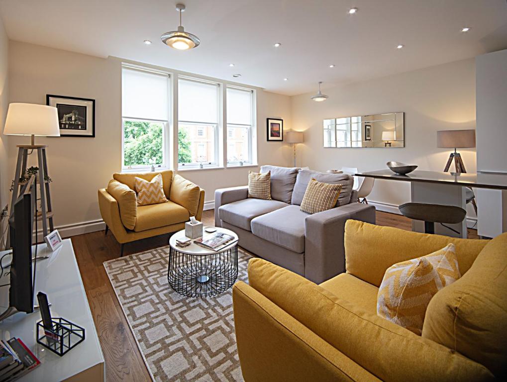 a living room with a couch and a table at Kensington High Street One Bed in London