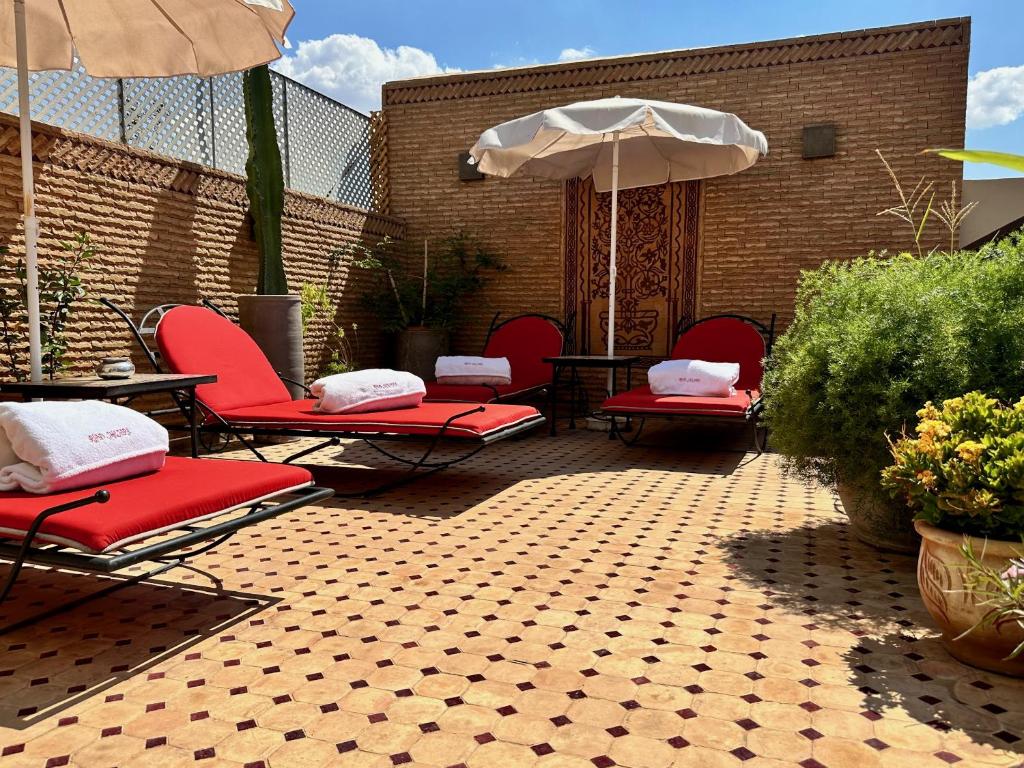 patio con sedie, tavolo e ombrellone di RIAD SHAJARA a Marrakech