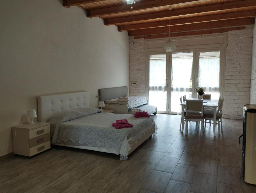 a bedroom with a bed and a table and chairs at Angelo's Country House in Bernalda