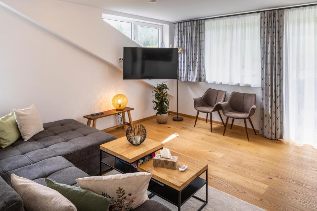 a living room with a couch and a tv at mivida - Apartment Geierkogel in Hohentauern