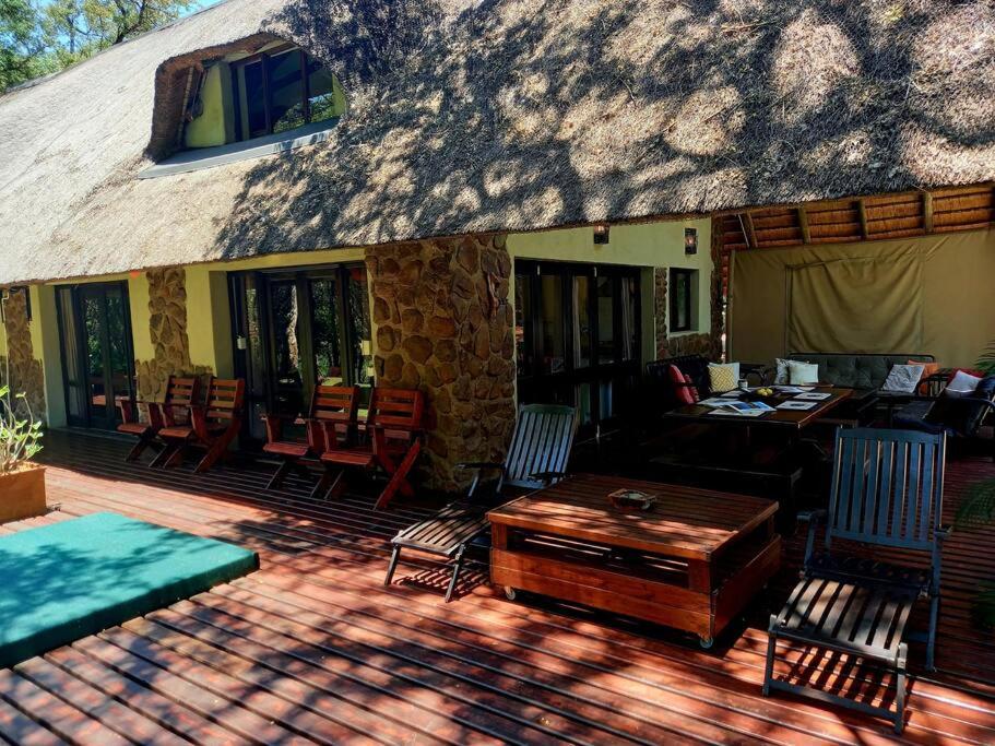 un patio con sillas y una mesa en una casa en Riverfront View - House on Blyde, en Kampersrus AH
