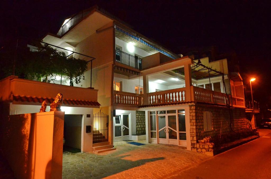 Une grande maison éclairée la nuit dans l'établissement Apartments Corovic, à Kotor