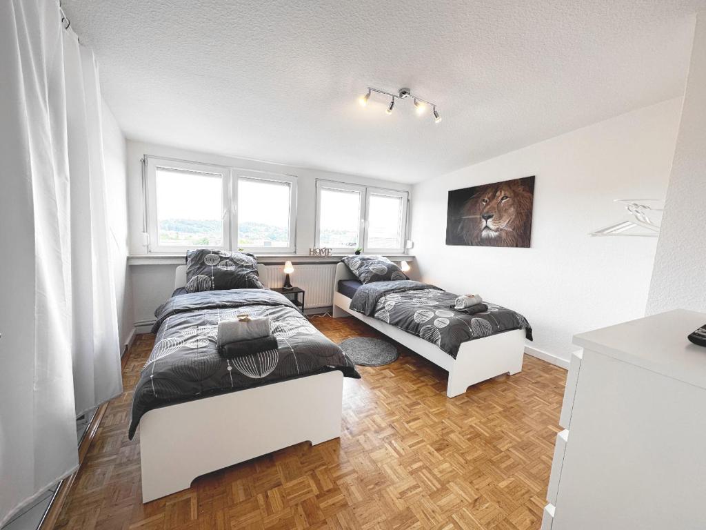 two beds in a room with two windows at # VAZ Apartments RS03 WLAN,TV, Küche, Parking, Autobahnähe in Remscheid