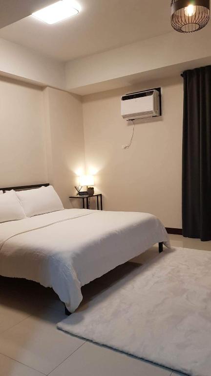 a bedroom with a bed and a air conditioner on the wall at 101 Newport blvd C2 4F by Rechelle Nunag in Manila