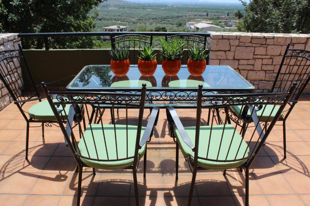 a patio table with four chairs and potted plants at Villa Khaki 