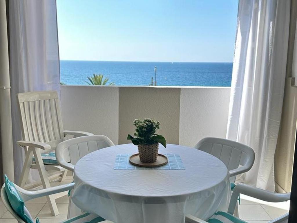 - une table blanche avec une plante en pot dans une pièce donnant sur l'océan dans l'établissement Appartement rénové 2 pièces Cannes, plage, piscines, parking privé - FR-1-609-5, à Cannes