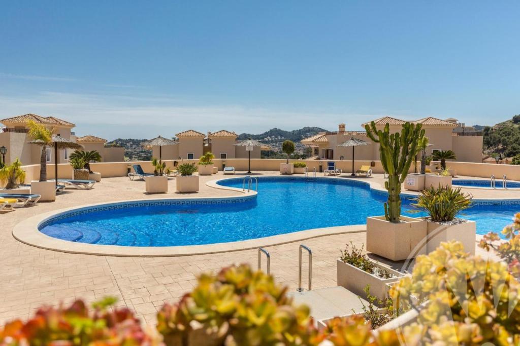 a pool at a resort with chairs and plants at La Manga Club Resort - Buena Vista 596 in Atamaría