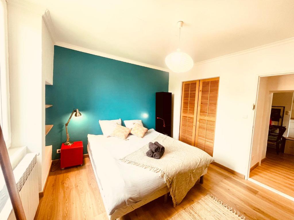 um quarto com uma cama e uma parede azul em Le Coeur De Nîmes em Nîmes