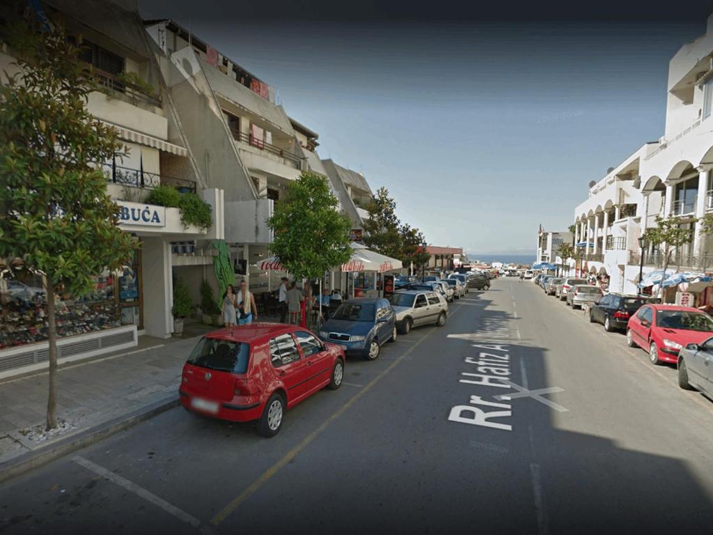 a red car parked on the side of a city street at Luxury Apartment in Ulcinj