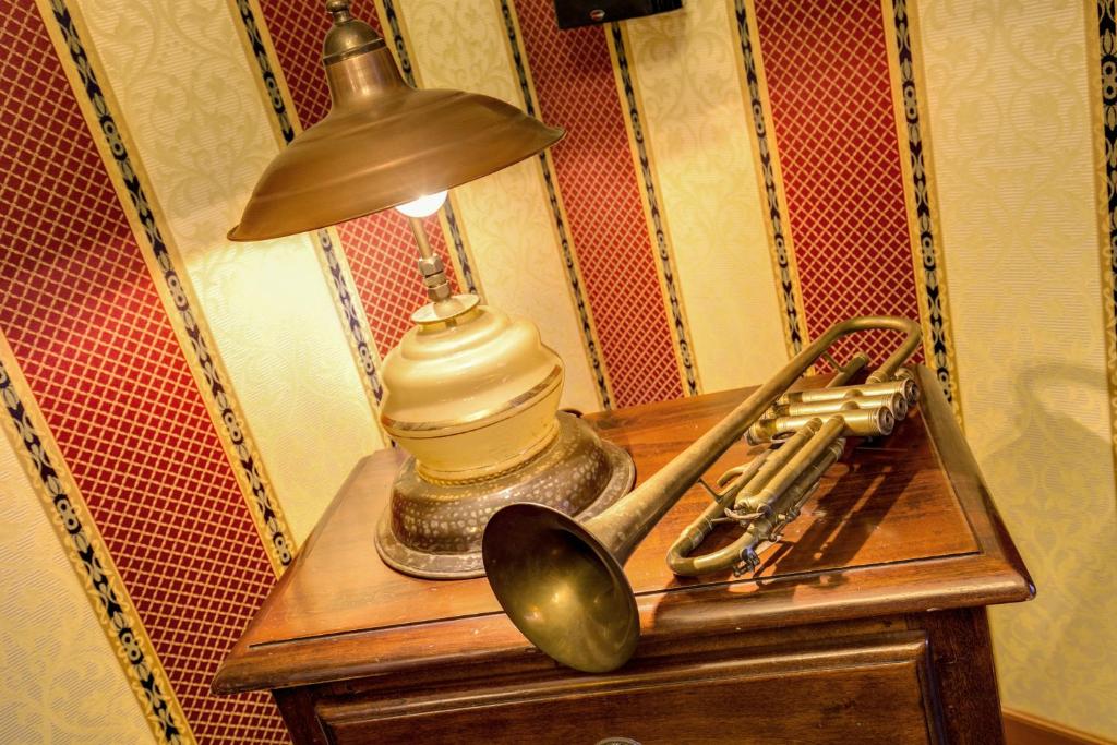 a lamp on a table with a saxophone and a trumpet at Hotel Oceania in Rome