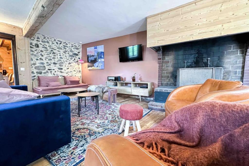 a living room with leather furniture and a stone fireplace at RIBERA 1 - Beautiful reformed house PARKING in Formiguères