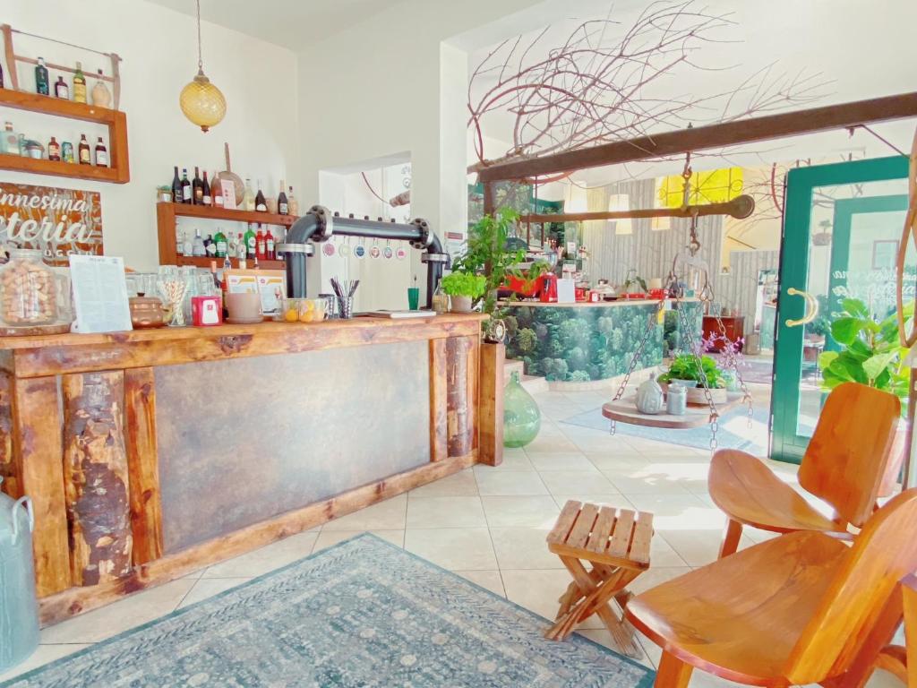 a bar with a counter and chairs in a room at Ennesima Osteria con Alloggio - Bike Hotel in Toscolano Maderno