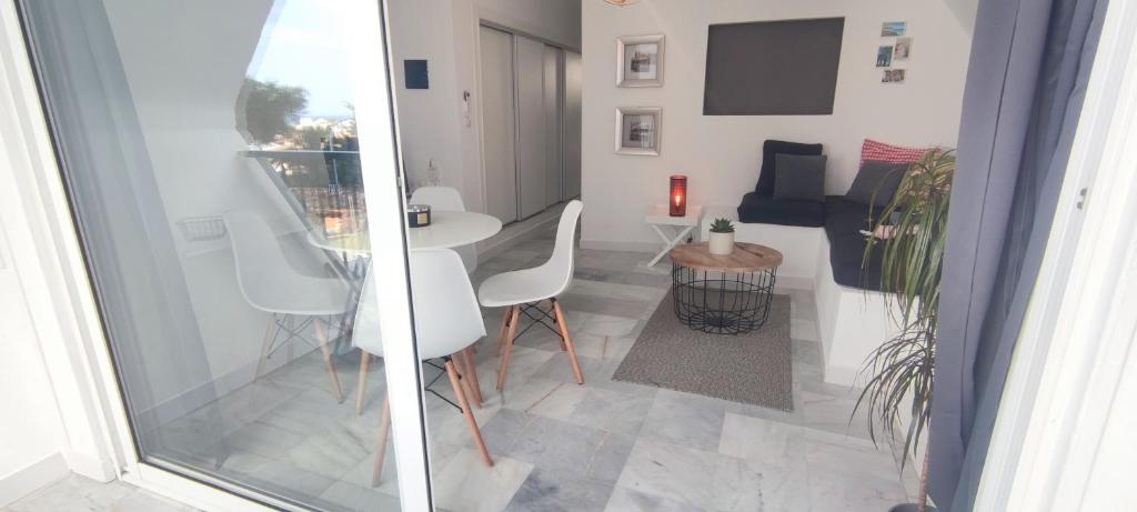 a living room with a white table and chairs at lovecosta apartamento sur in Torremolinos