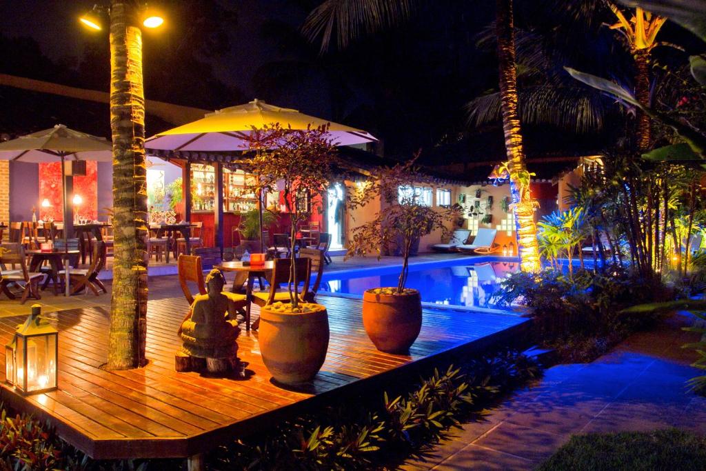 um resort com piscina à noite em Hotel Pousada Coqueiros em Arraial d'Ajuda