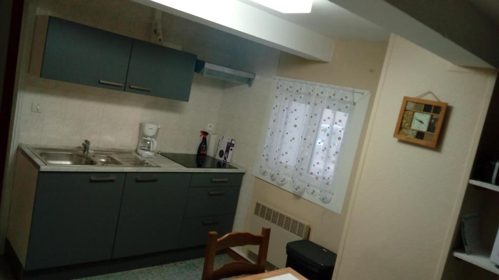 une cuisine avec des armoires vertes et un évier dans l'établissement appartement proche de la plage, à Merlimont