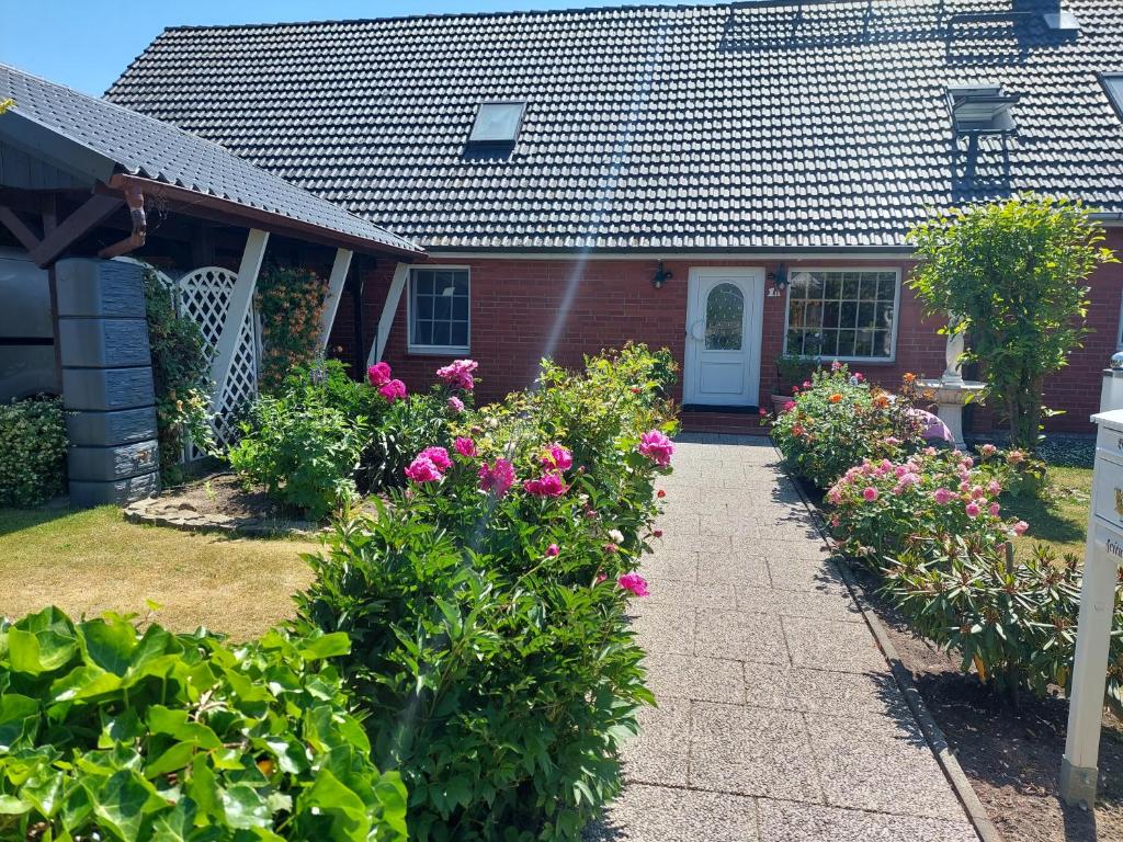 a house with pink flowers in front of it at Ferienwohnung am Schweriner See in Retgendorf