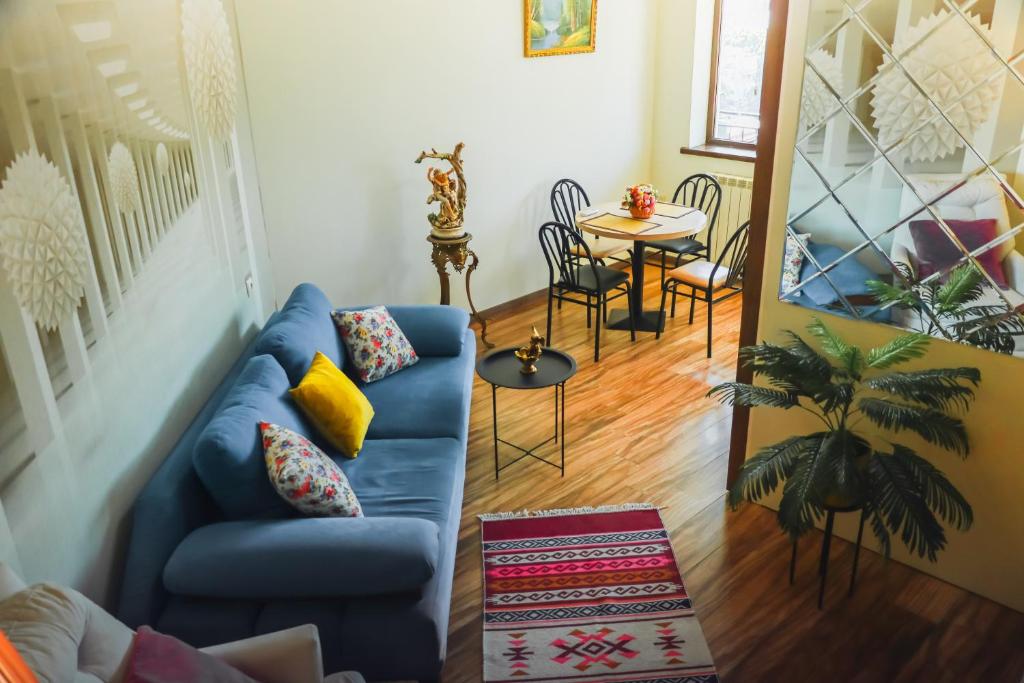een woonkamer met een blauwe bank en een tafel bij Lika's apartment with a marvelous view in Tbilisi City