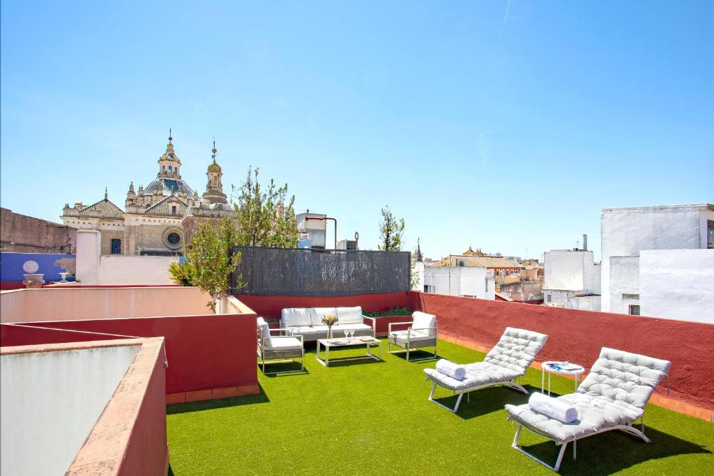 un patio con sillas y mesas en la azotea en Genteel Home Salvador Terrace, en Sevilla