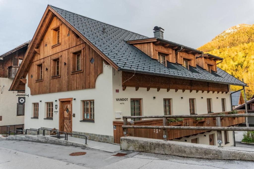 ein Gebäude mit einem Holzdach in der Unterkunft Hotel Vandot in Kranjska Gora