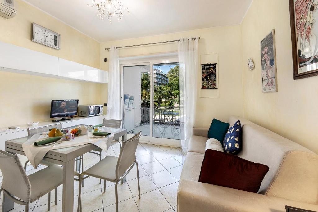 uma sala de estar com um sofá e uma mesa em Anna Station Near Sea - Happy Rentals em Sanremo