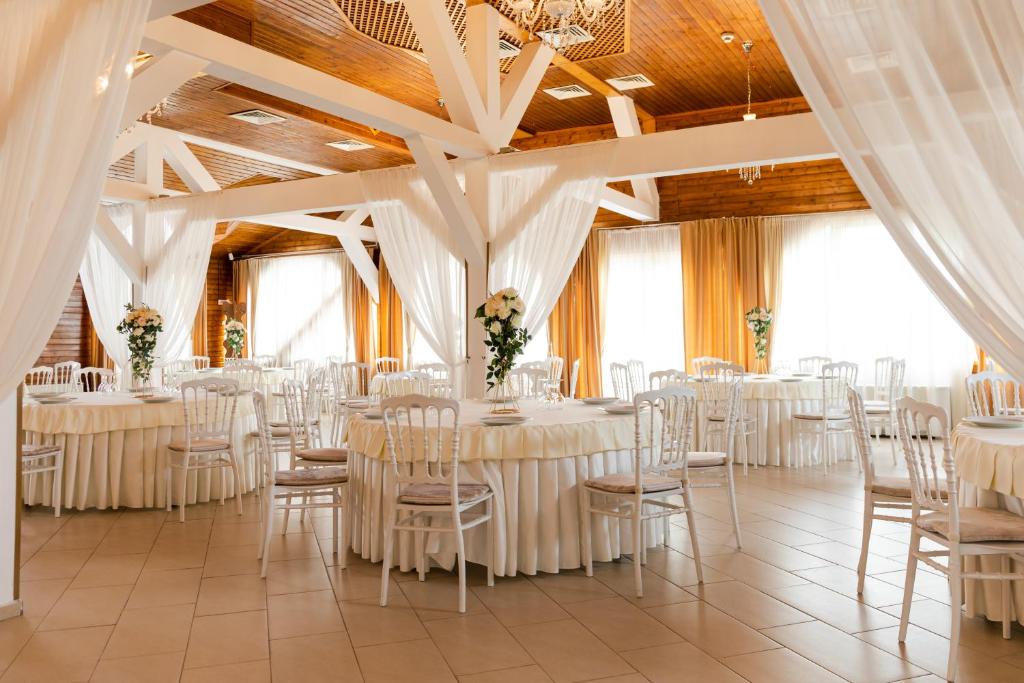 a banquet hall with white tables and chairs at Complex Turistic Darina Sancraiu de Mures in Sîncraiu de Mureş