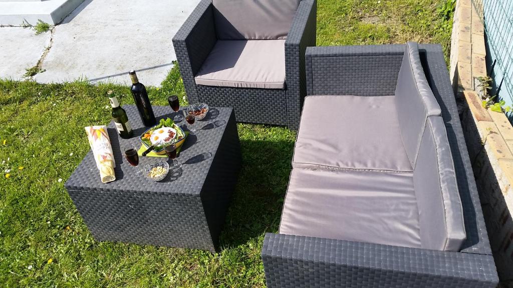 a table with a bottle of wine and some wine glasses at STADE OLYMPIQUE A PIED Colombes Parking jardin Wifi in Colombes
