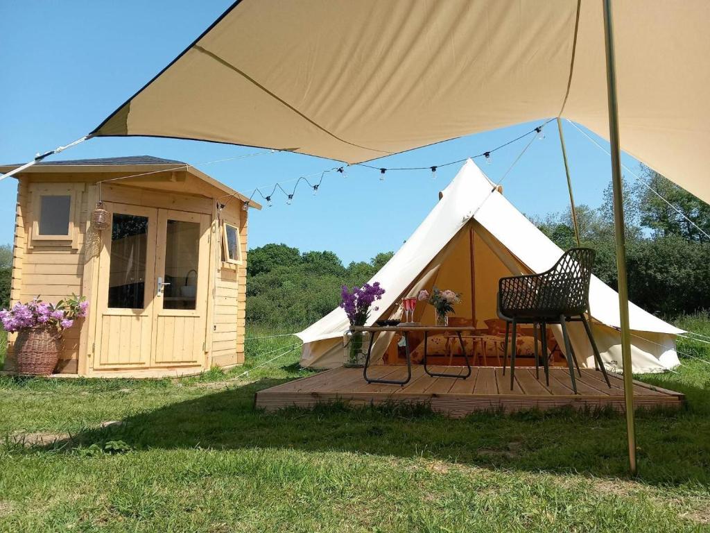 a tent with a table in front of it at La tente de kergomar in Ploumilliau