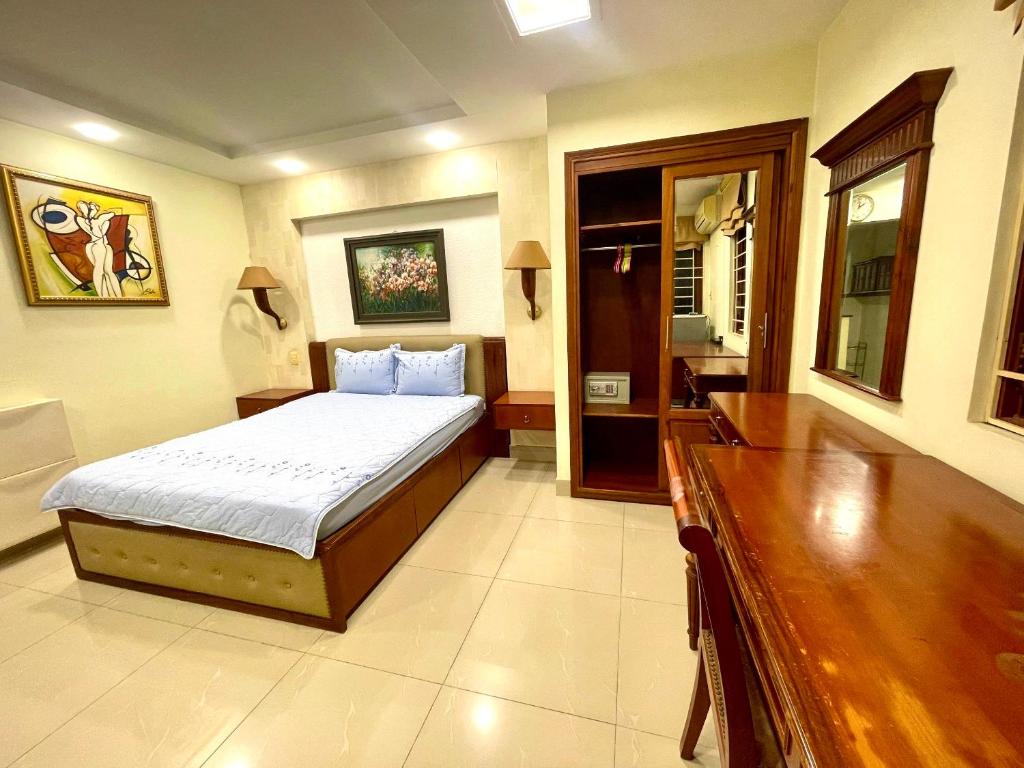 a bedroom with a bed and a dresser in it at Nanwa House in Ho Chi Minh City