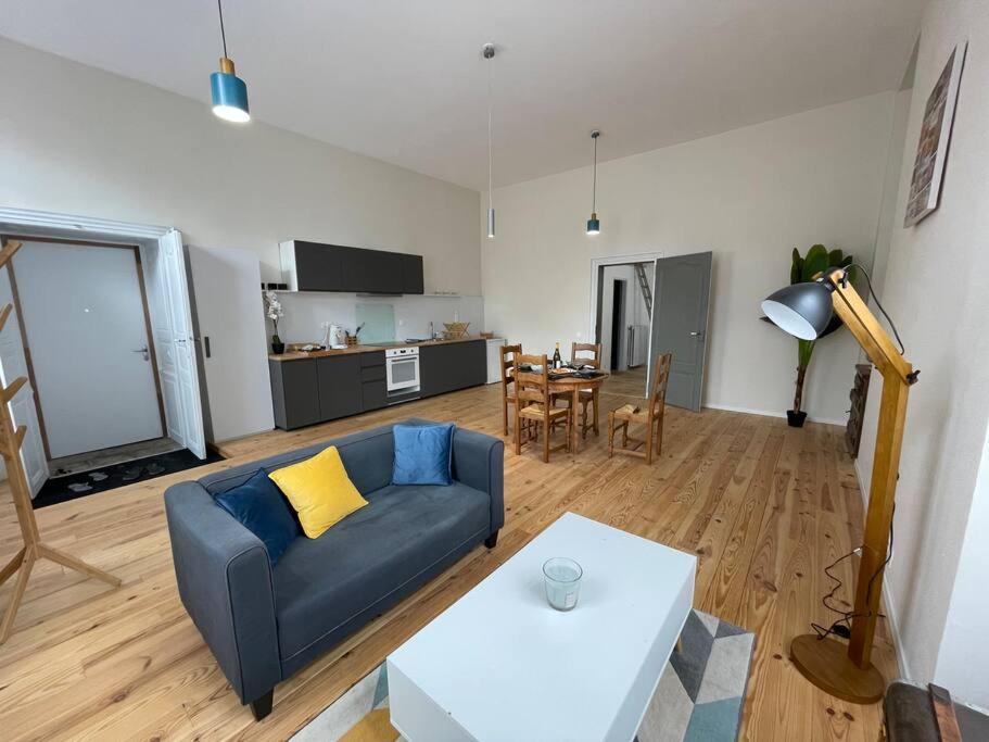 ein Wohnzimmer mit einem blauen Sofa und einem Tisch in der Unterkunft Superbe appartement lumineux in Guéret