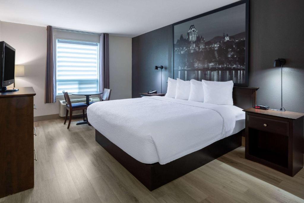 A bed or beds in a room at Super 8 by Wyndham Quebec City
