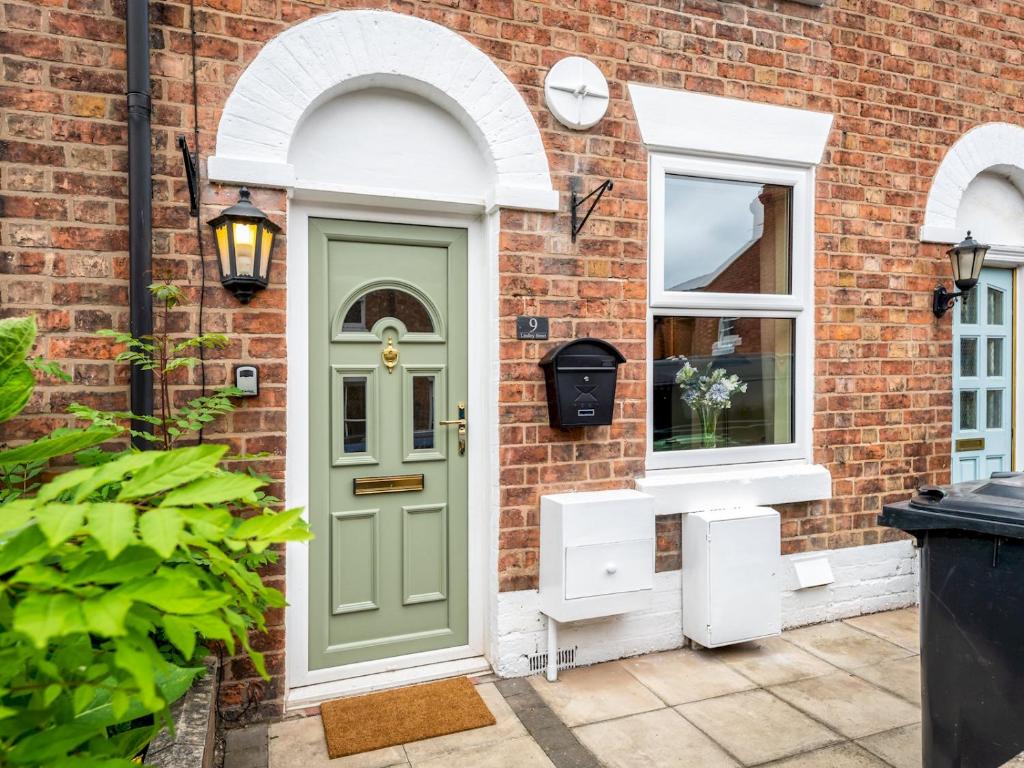 a green door and a window on a brick house at Pass the Keys Stylish newly renovated Victorian 2 bedroom house in Shrewsbury