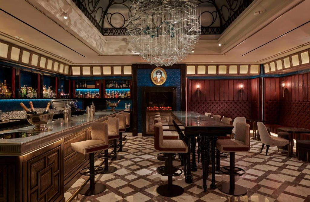 a restaurant with a bar with a chandelier at Great Scotland Yard Hotel, part of Hyatt in London