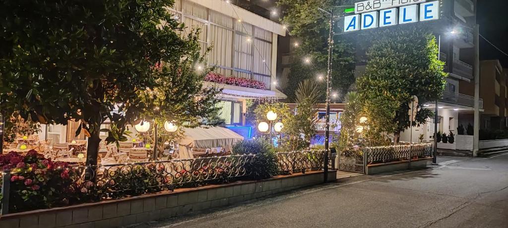 un edificio con una cafetería en la calle por la noche en Hotel Adele, en Bellaria-Igea Marina